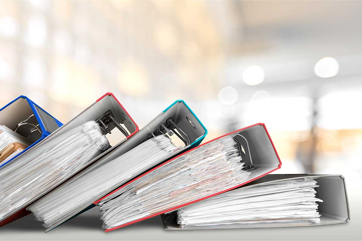 Manuals binders stacked overlapping on a table.